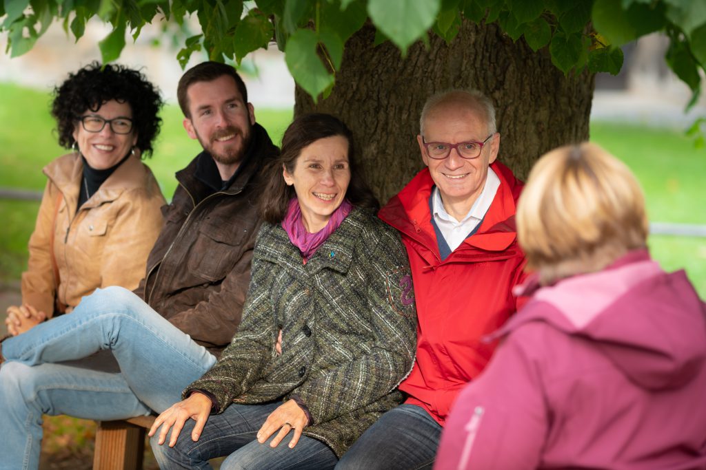 Thomas Semmelmann engagiert sich für seine Region und unterhält sich hier mit drei Frauen und zwei Männern sitzend auf einer Bank unter einem Baum